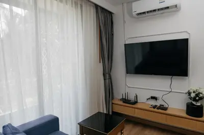 a living room with a tv and a blue couch at Aristo 2 Phuket, Surin beach in Surin Beach