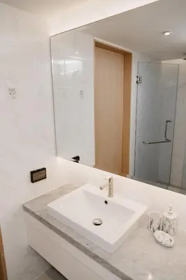 a white bathroom with a sink and a mirror at Aristo 2 Phuket, Surin beach in Surin Beach