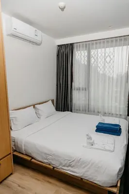 a bedroom with a large white bed with a window at Aristo 2 Phuket, Surin beach in Surin Beach