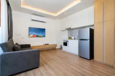 a living room with a couch and a refrigerator at Aristo 2 Phuket, Surin beach in Surin Beach
