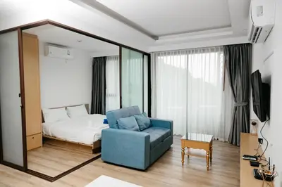 a living room with a bed and a blue chair at Aristo 2 Phuket, Surin beach in Surin Beach