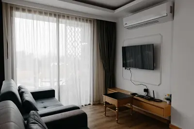 a living room with a couch and a flat screen tv at Aristo 2 Phuket, Surin beach in Surin Beach