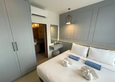 a bedroom with a white bed with towels on it at Modern Condo Palmyrah by Lofty in Surin Beach