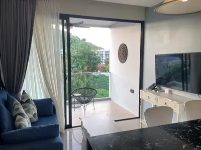 a living room with a blue couch and a television at Modern Condo Palmyrah by Lofty in Surin Beach