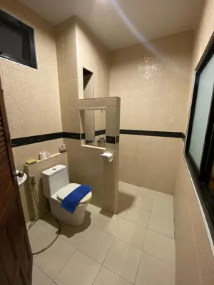 a bathroom with a toilet with a blue seat at Кондо в райском уголке Равай in Rawai Beach