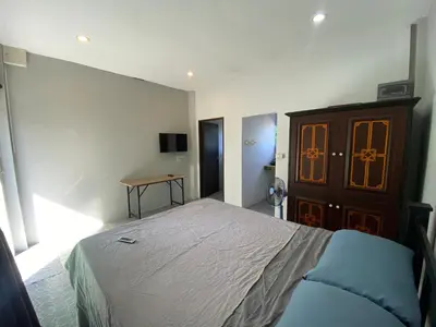 a bedroom with a bed and a wooden cabinet at Кондо в райском уголке Равай in Rawai Beach