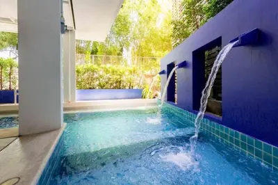 a blue swimming pool with a water fountain at Coco boutique hotel in Patong Beach