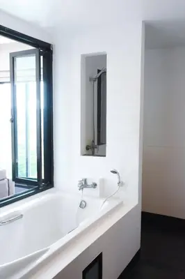a white bathroom with a sink and a window at Coco boutique hotel in Patong Beach