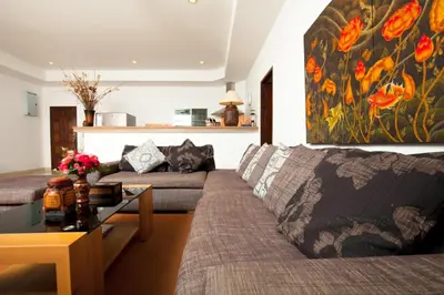 a living room with a couch and a table at Romanee Villa by G Estate in Rawai Beach