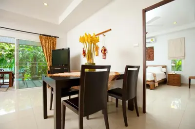 a dining room with a table and chairs and a bedroom at Romanee Villa by G Estate in Rawai Beach