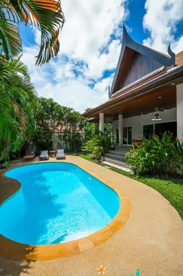 a swimming pool in front of a house at Romanee Villa by G Estate in Rawai Beach