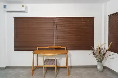 a wooden table and chair in a room with a window at Montaplan Villa by G Estate in Rawai Beach