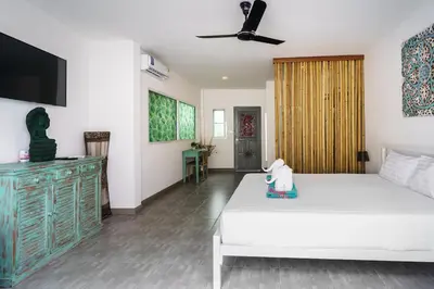 a bedroom with a white bed and a tv at Montaplan Villa by G Estate in Rawai Beach