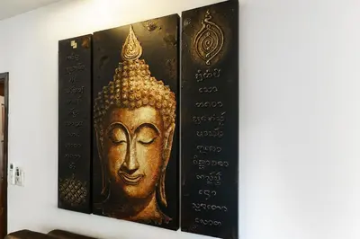 a gold buddha painting hanging on a wall at Meursault Villa by G Estate in Rawai Beach