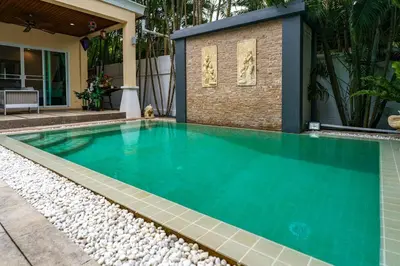 a swimming pool in a house with blue water at Meursault Villa by G Estate in Rawai Beach