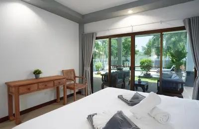 a bedroom with a bed and a desk and a balcony at Montrachet Villa by G Estate in Rawai Beach