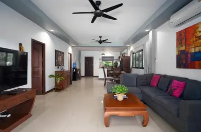 a living room with a couch and a table at Montrachet Villa by G Estate in Rawai Beach