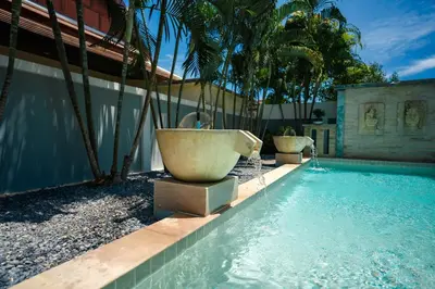 a swimming pool with a bath tub and palm trees at Montrachet Villa by G Estate in Rawai Beach