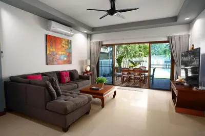 a living room with a couch and a tv at Montrachet Villa by G Estate in Rawai Beach
