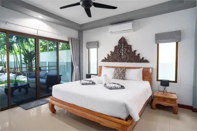 a bedroom with a large bed and a ceiling fan at Montrachet Villa by G Estate in Rawai Beach