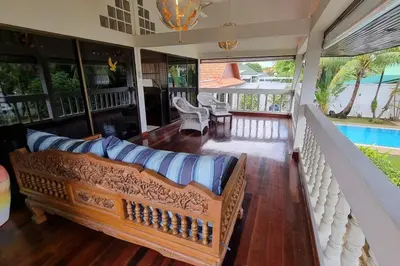 a living room with a couch and a pool at Baan Paa Phuket - 6 Bedrooms Villa in Rawai Beach