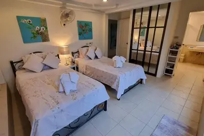 a bedroom with two beds with towels on them at Baan Paa Phuket - 6 Bedrooms Villa in Rawai Beach