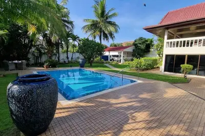 a pool with a large vase next to a house at Baan Paa Phuket - 6 Bedrooms Villa in Rawai Beach