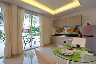 a kitchen and dining room with a table and chairs at The Inspiration Residence in Rawai Beach