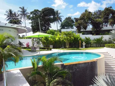 a swimming pool in the backyard of a house at The Inspiration Residence in Rawai Beach
