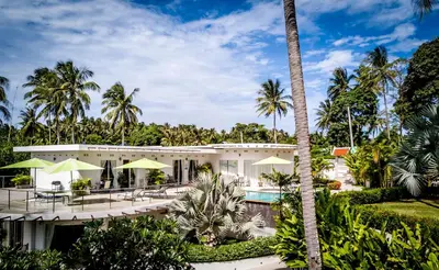 a house with a swimming pool and palm trees at The Inspiration Residence in Rawai Beach