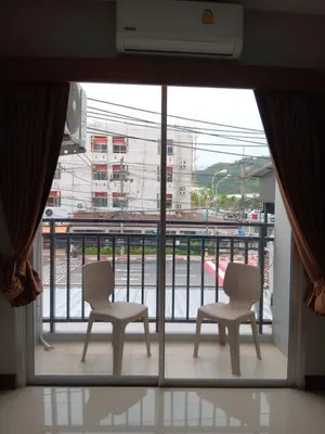 two chairs on a balcony with a view of a street at The Brown Boutique Patong in Patong Beach
