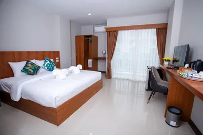 a bedroom with a bed and a desk with a computer at The Brown Boutique Patong in Patong Beach