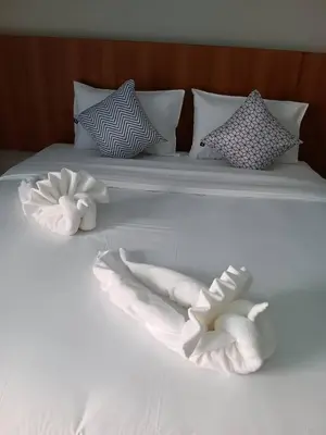 a white bed with two towel animals on it at The Brown Boutique Patong in Patong Beach