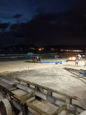 a beach at night with people on the sand at The Brown Boutique Patong in Patong Beach