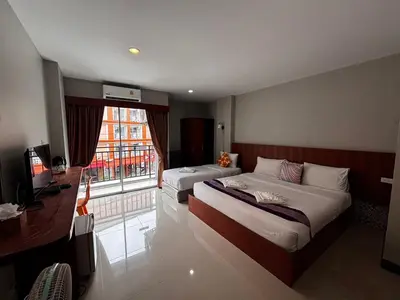 a hotel room with two beds and a window at The Brown Boutique Patong in Patong Beach