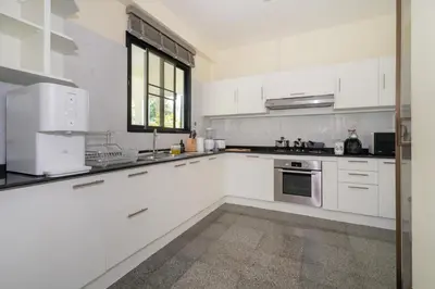 a white kitchen with white appliances and a window at Rawai - 3 BR Private Pool Villa - Phoomjai Villa in Rawai Beach