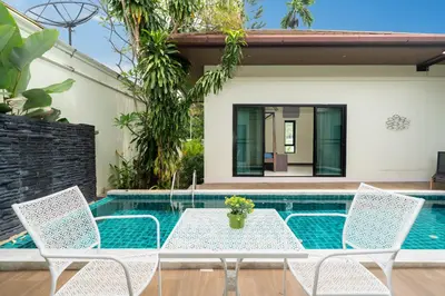 a patio with a table and chairs next to a swimming pool at Rawai - 3 BR Private Pool Villa - Phoomjai Villa in Rawai Beach