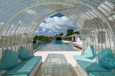 an archway over a pool at a resort with blue cushions at Villa Arun in Phuket Town