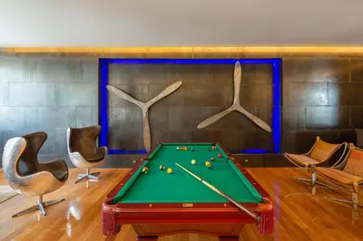 a room with a pool table and some chairs at Villa Arun in Phuket Town