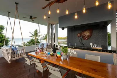 a kitchen with a long wooden table and chairs at Villa Arun in Phuket Town