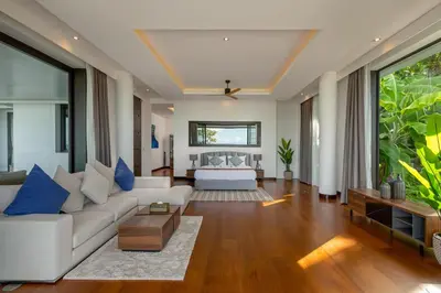 a living room with a white couch and blue pillows at Villa Arun in Phuket Town