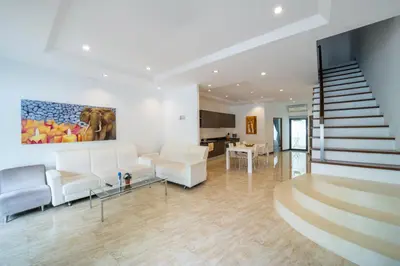 a living room with white furniture and a staircase at Kamala Beach 3-bedroom villa near Fantasea with high-speed Wi-Fi and private pool in Kamala Beach
