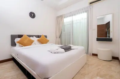 a large white bed in a room with a window at Kamala Beach 3-bedroom villa near Fantasea with high-speed Wi-Fi and private pool in Kamala Beach