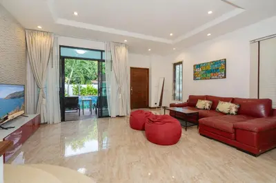 a living room with a red couch and a table at Kamala Beach 3-bedroom villa near Fantasea with high-speed Wi-Fi and private pool in Kamala Beach