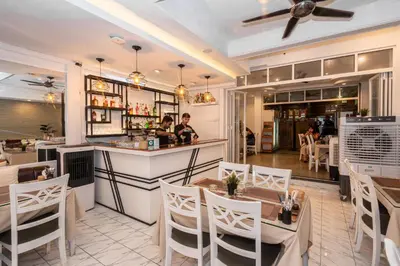 a restaurant with tables and chairs and a bar at Patong Social Hotel & Restaurant in Patong Beach