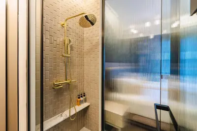 a bathroom with a shower with a glass door at Bandalo Boutique Hotel - Patong Beach Road in Patong Beach