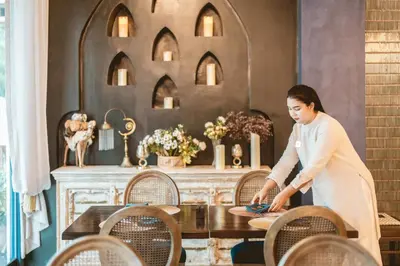 a woman is standing in front of a table at Bandalo Boutique Hotel - Patong Beach Road in Patong Beach