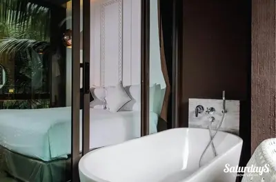 a bathroom with a white sink and a bed at Saturays condo One Bedroom Suite 178 in Ban Saiyuan (1)