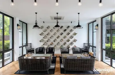 a living room with a table and chairs and windows at Saturays condo One Bedroom Suite 178 in Ban Saiyuan (1)