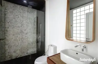 a bathroom with a sink and a toilet and a mirror at Saturays condo One Bedroom Suite 178 in Ban Saiyuan (1)
